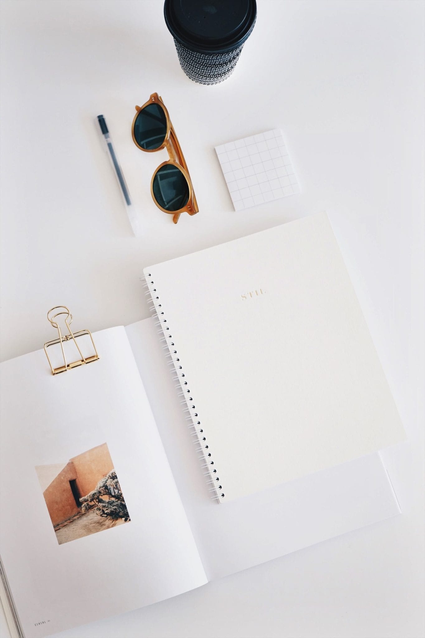 journal flat lay with sunglasses and coffee cup