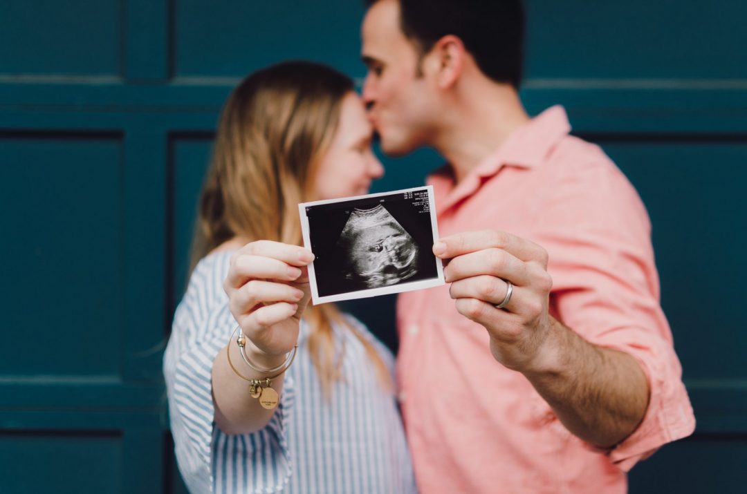 couple holding an ultrasound being pregnant in Italy