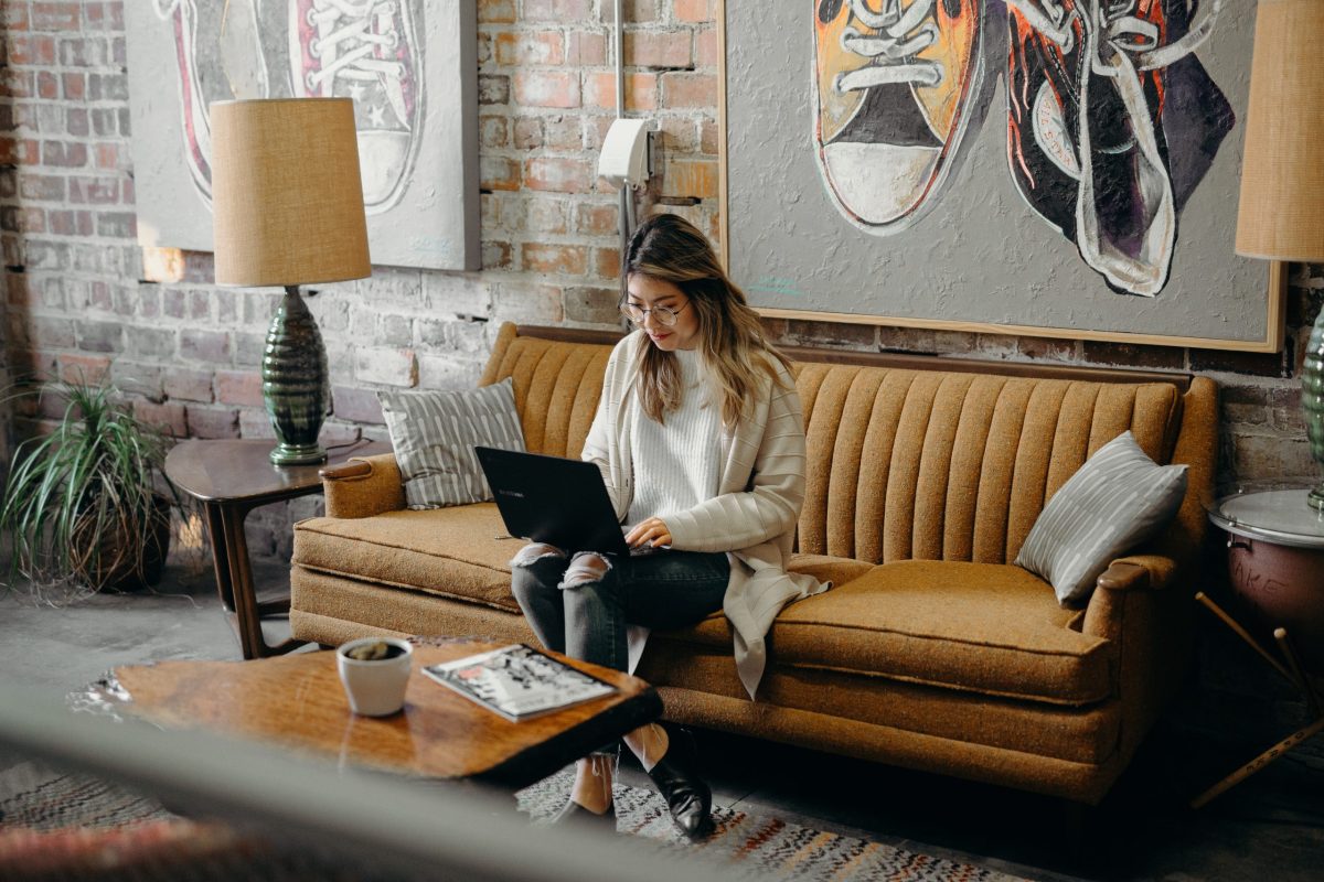 working from couch on laptop searching jobs in italy