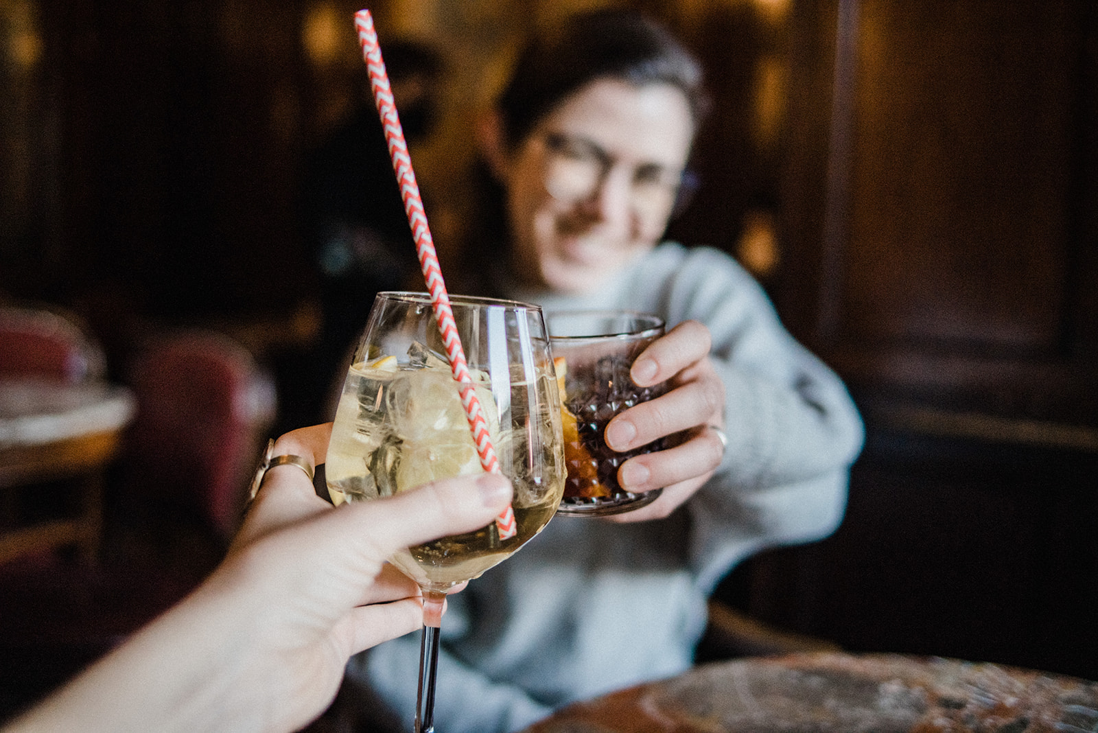 clinking glasses with a girl in background, two friends in Italy