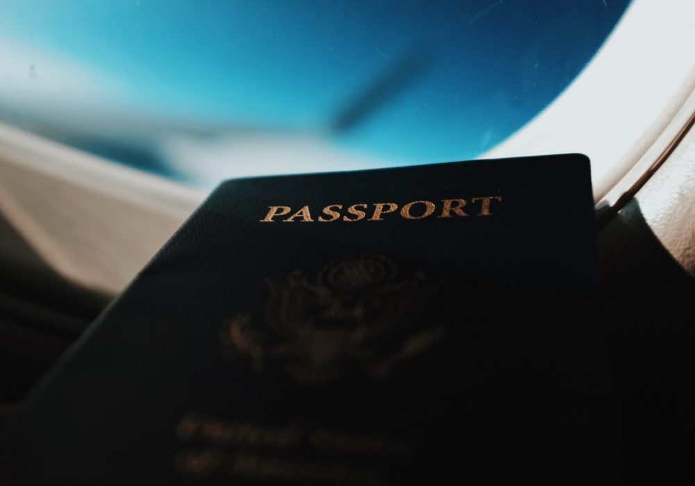 passport in airplane window going to apply for the permesso di soggiorno italy