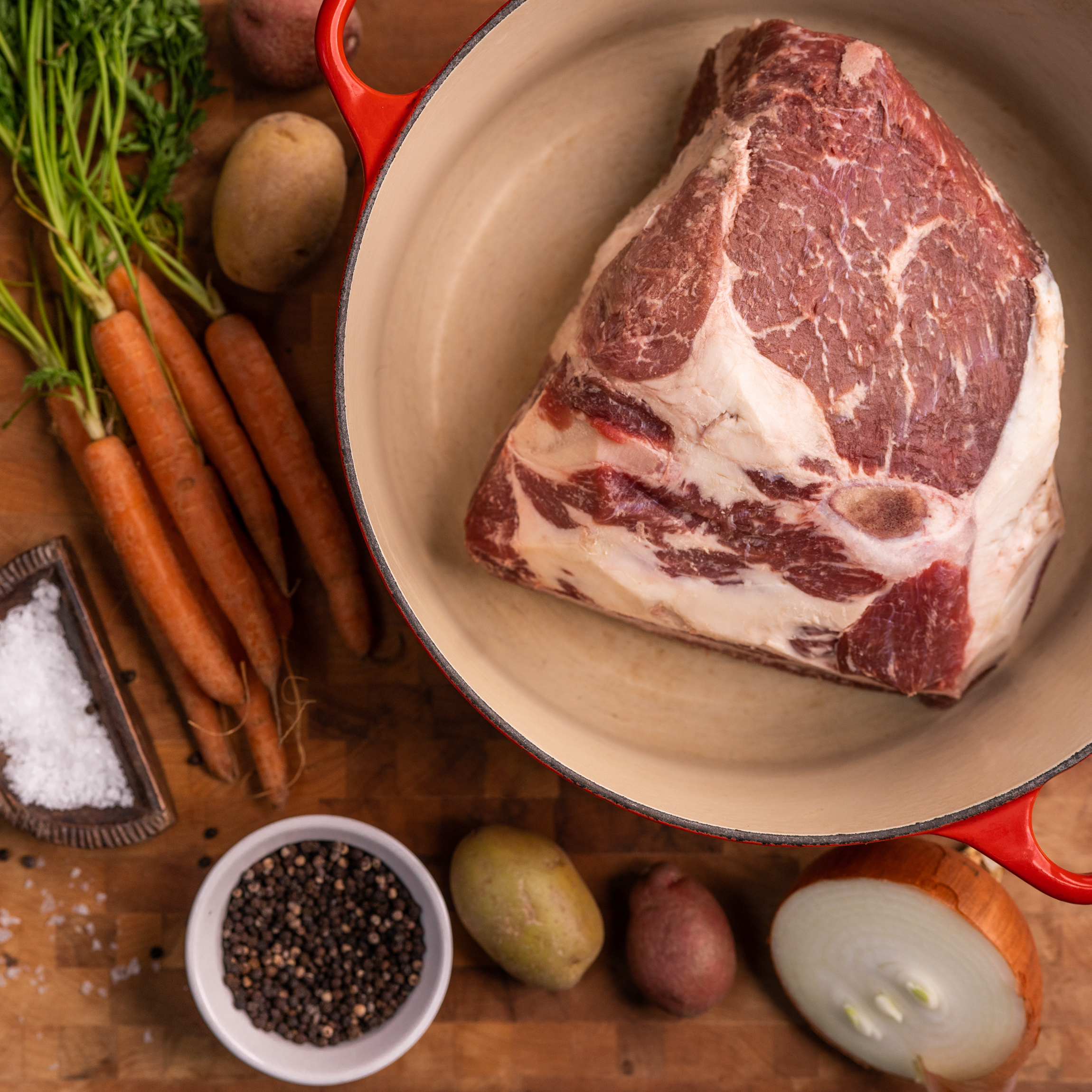 Rump roast ready with carrots and seasoning ready to cook.