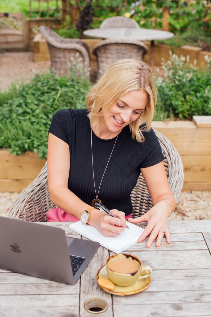 Kellie sat at table writing in notebook - keeping track of key dates