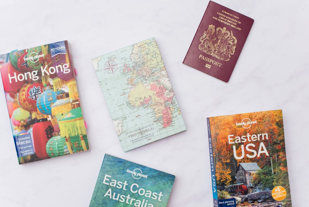 Travel books, passport and map ready for a business trip.