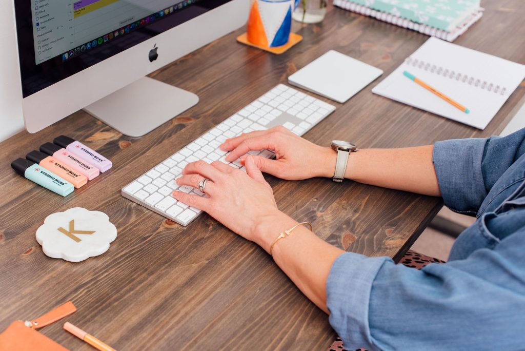 Woman sat at desk typing on keyboard